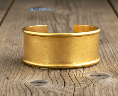 Hammered 24k 9999 gold bracelet cuff Ancient Rome style on old wooden surface with 'Ella Kripaka' branding