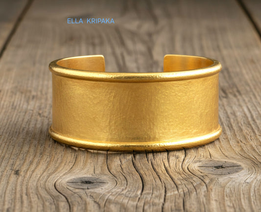 Hammered 24k 9999 gold bracelet cuff Ancient Rome style on old wooden surface with 'Ella Kripaka' branding