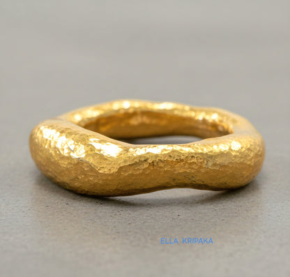 Hammered 24k 9999 Gold thick uneven ring organic signet with a textured gold surface on a grey concrete background, branded 'Ella Kripaka'
