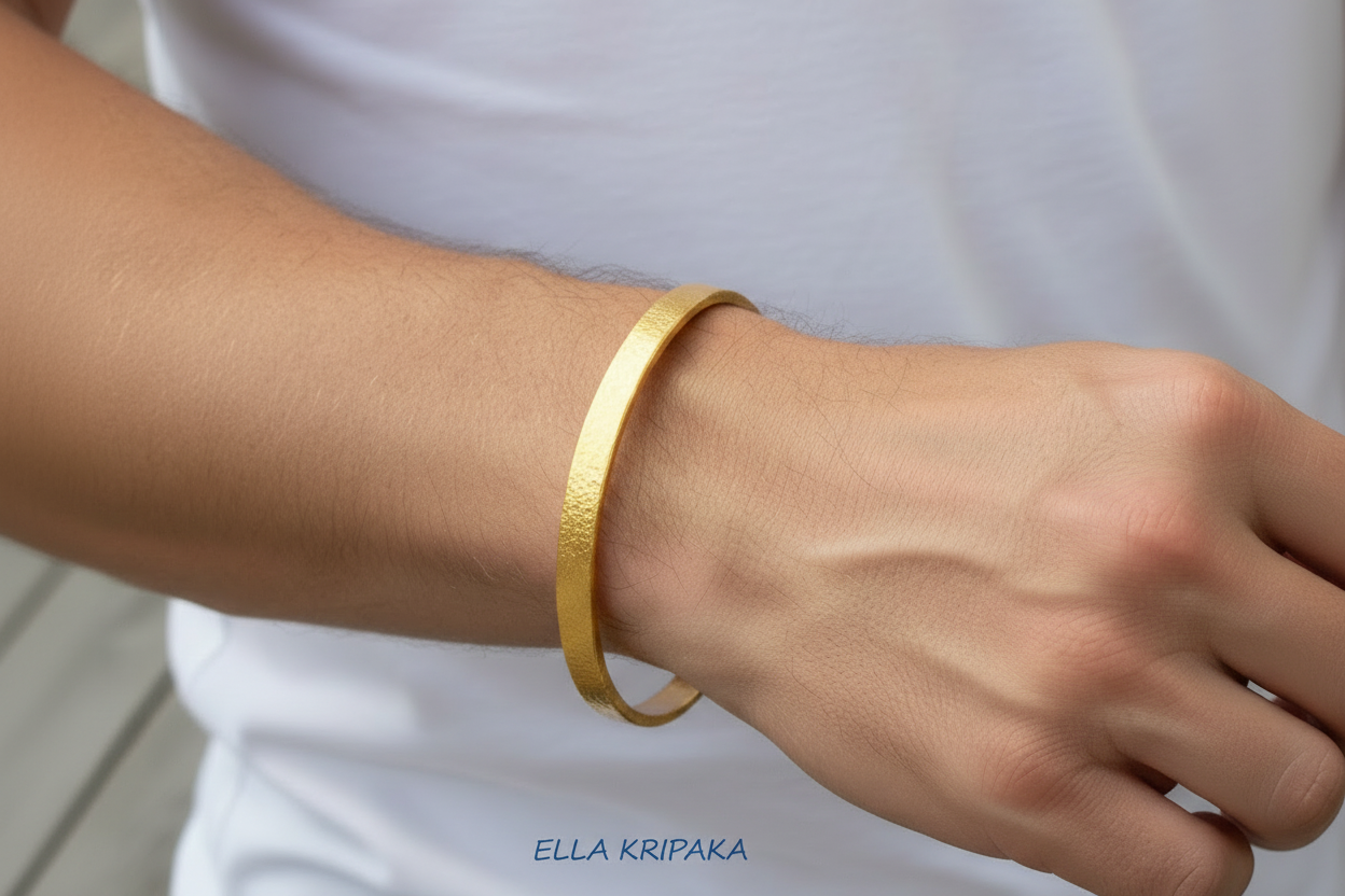 Hammered 24k 9999 gold bangle thick bracelet Ancient Rome style worn by a woman on hand and on a white t-shirt background, artist-jeweler name 'Ella Kripaka' branding