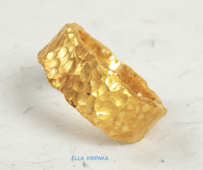 Organic hammered 24k 9999 Gold ring with uneven edges on white paper surface, artist-jeweler's name 'Ella Kripaka' is written in picture
