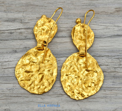 Organic 24k 9999 gold hammered wavy uneven earrings shiny gold textures are on old wooden background, artist-jeweler's name 'Ella Kripaka'