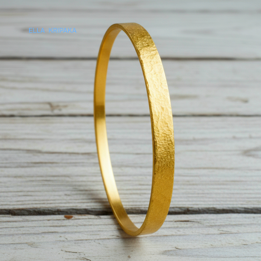 24k 9999 gold hammered Ancient Rome style bracelet bangle on white rustic wooden surface, indicating it is a custom-made jewelry with creator's name 'Ella Kripaka'