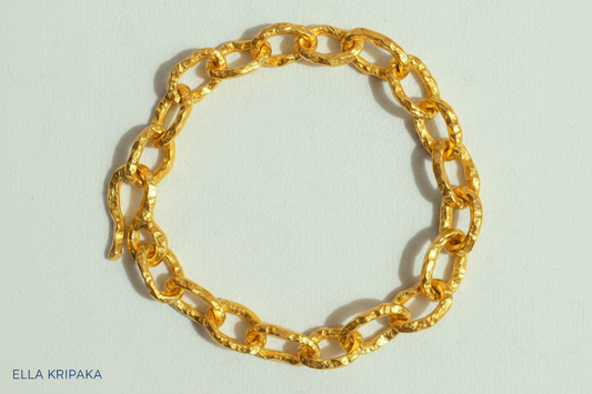 Hammered 24k 9999 gold organic bracelet chain with hammered uneven textures and a thick hook clasp on white surface, artist name 'Ella Kripaka'