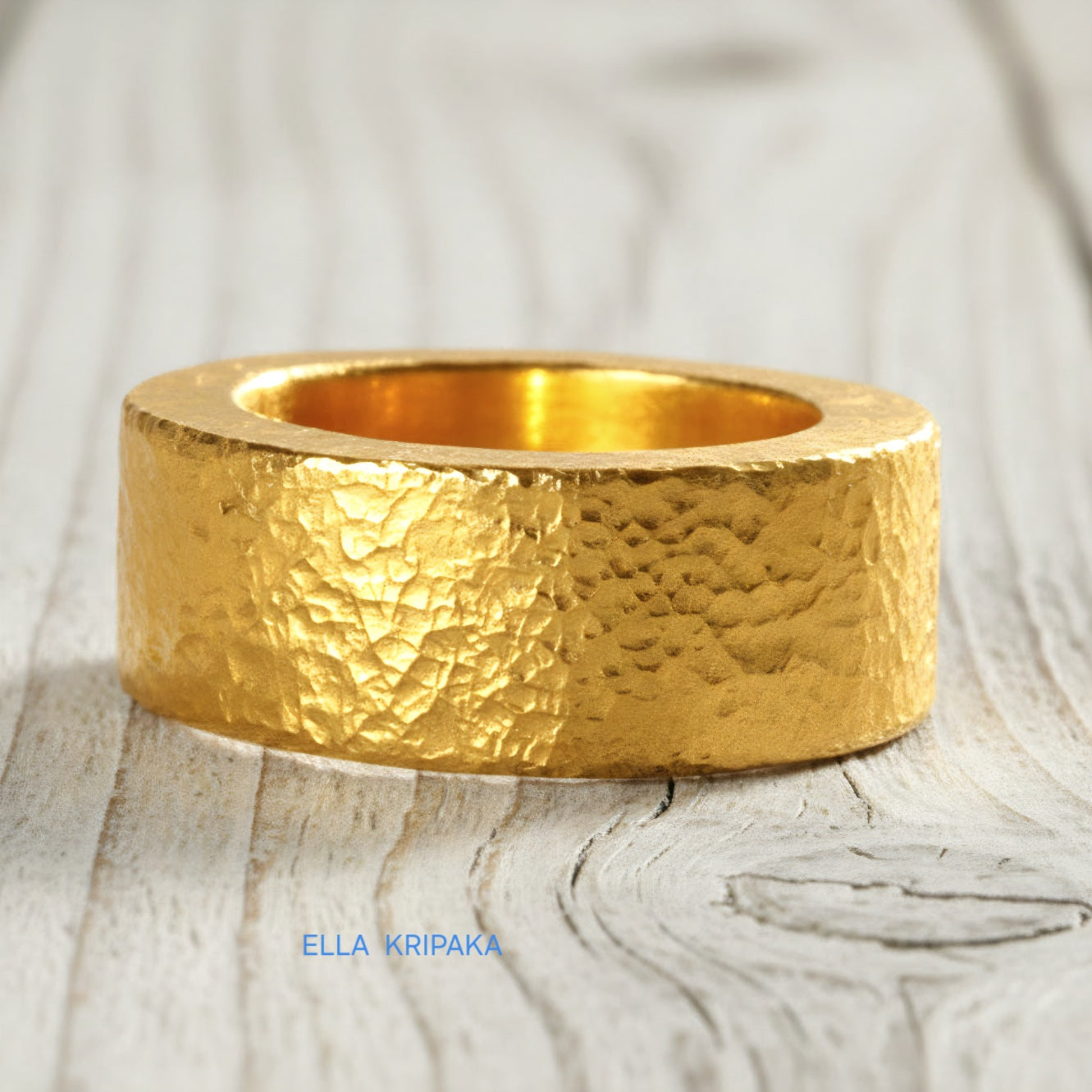 Hammered 24k Gold 9999 gold Ancient Rome  thick ring band with textured gold on a white rustic wooden background, branded 'Ella Kripaka'