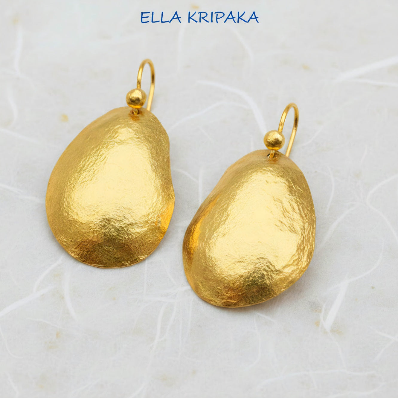 organic 24k 9999 gold hammered uneven convex oval earrings with forged gold textures on a white paper surface, artist's name 'Ella Kripaka'