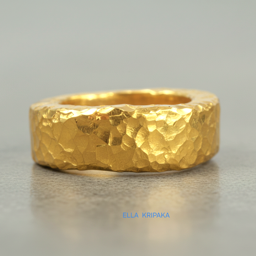 Hammered 24k 9999 Gold thick uneven ring organic with a textured gold surface on a grey concrete background, branded 'Ella Kripaka'