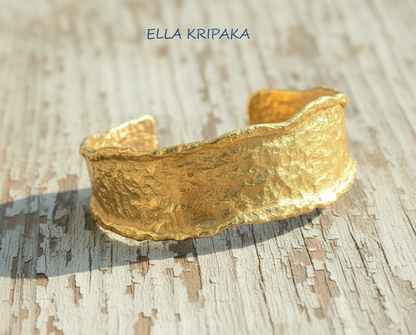 Organic hammered 24k 9999 gold bracelet uneven cuff on a old white wooden background, branding artist-jeweler name 'Ella Kripaka'