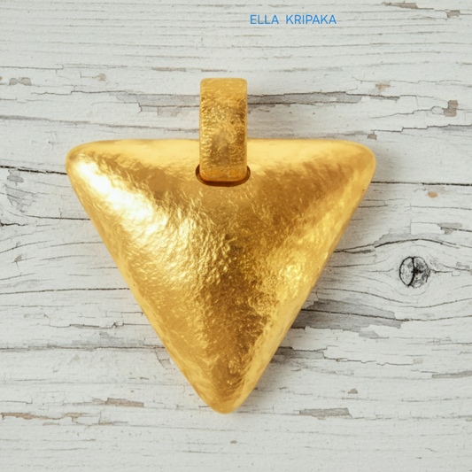 Hammered 24k gold convex triangle pendant on a white rustic wooden background with 'Ella Kripaka' branding