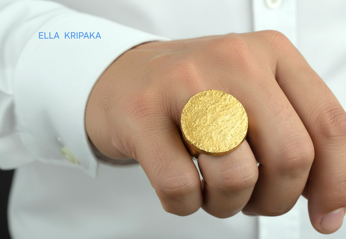 Hammered 24k 9999 Gold thick ring disk signet Ancient Rome style and Byzantine style with a textured gold worn by a man on finger against a white background, branded 'Ella Kripaka'